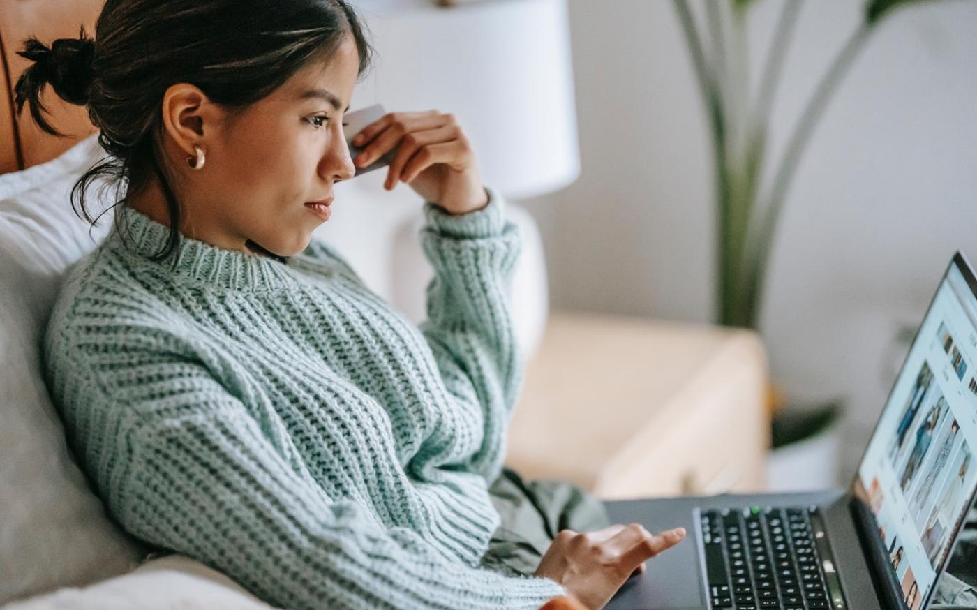 Focused young woman shopping online on her laptop