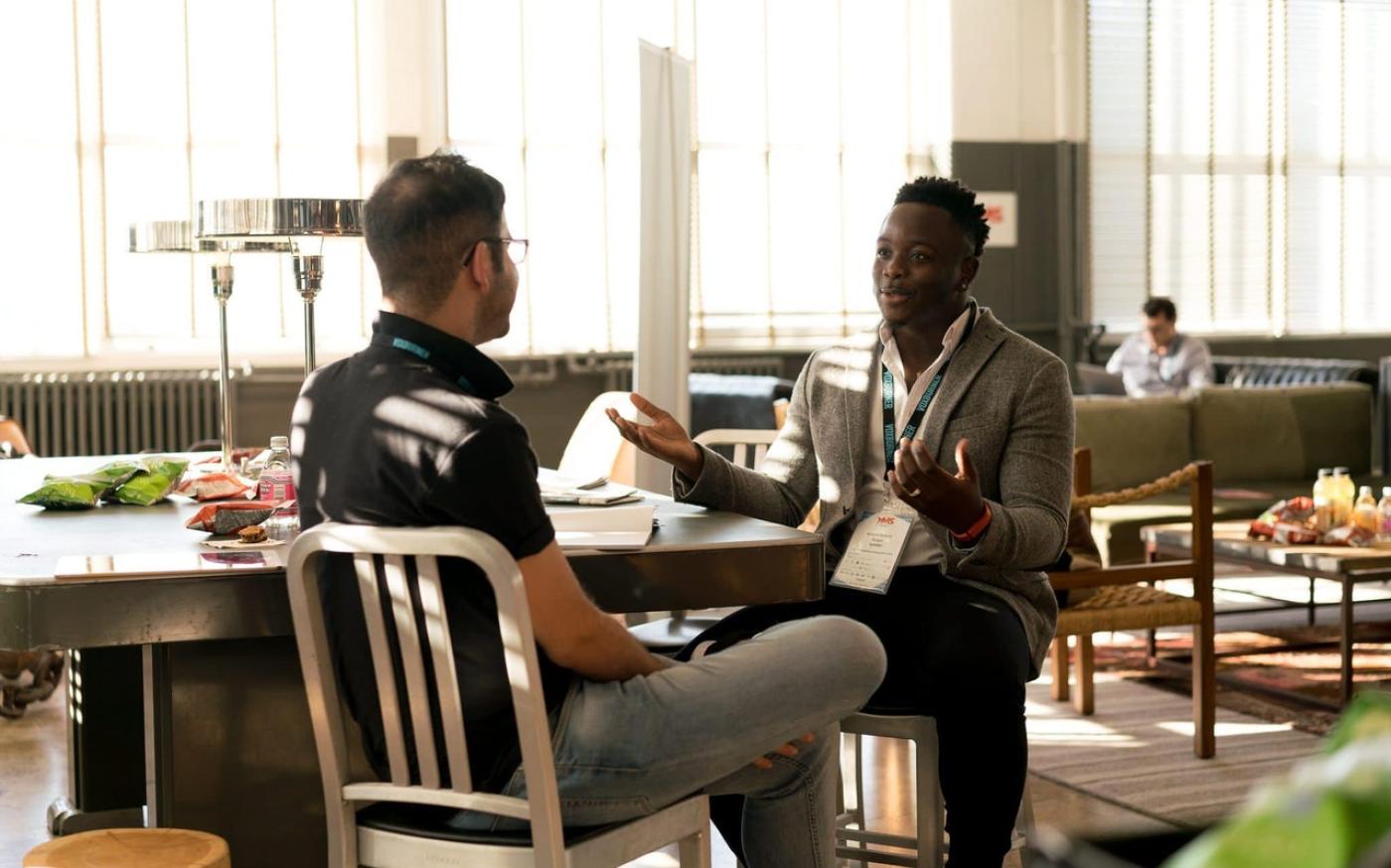 Two men sitting at a table and having a conversation