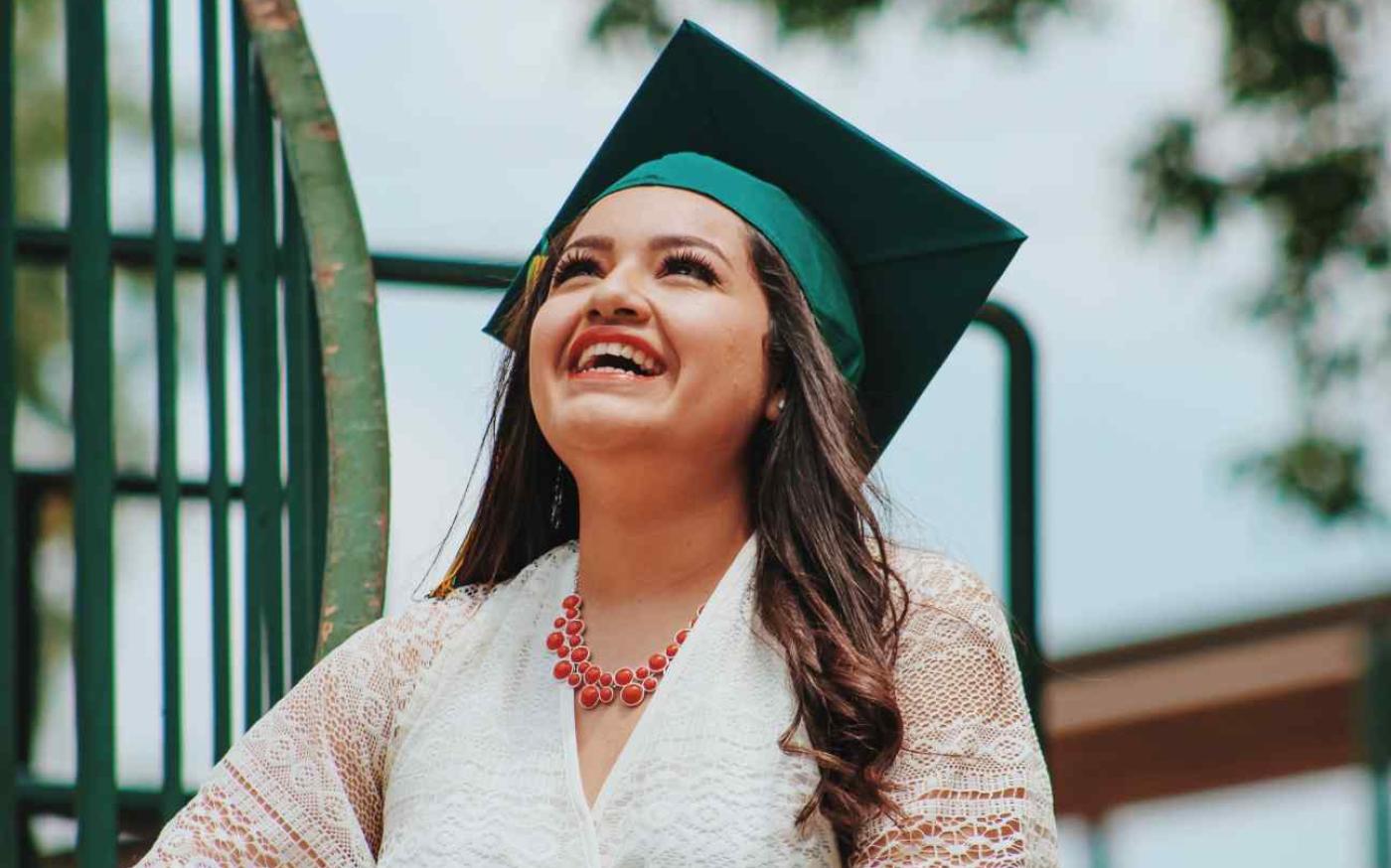 Woman with graduation cap looking at the sky