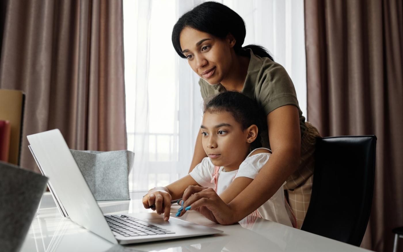 Mother and child working on a laptop together