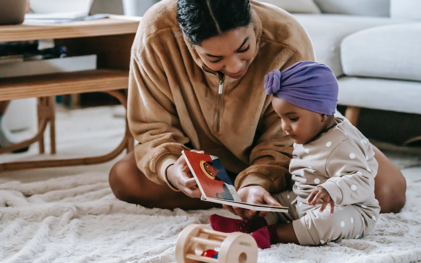 Parent reading a book to their newborn child